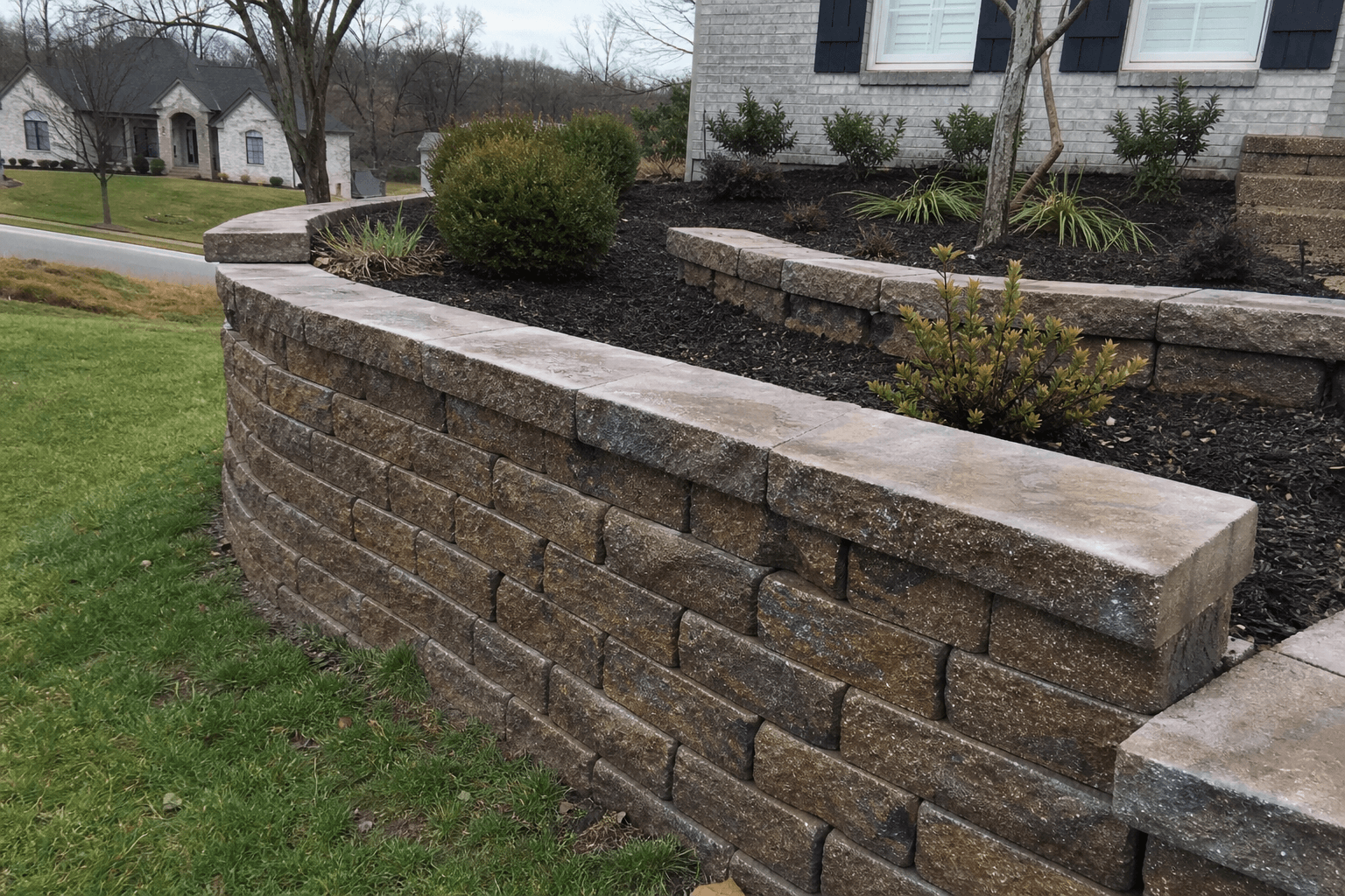 Tiered retaining wall with stone steps and front yard landscaping.